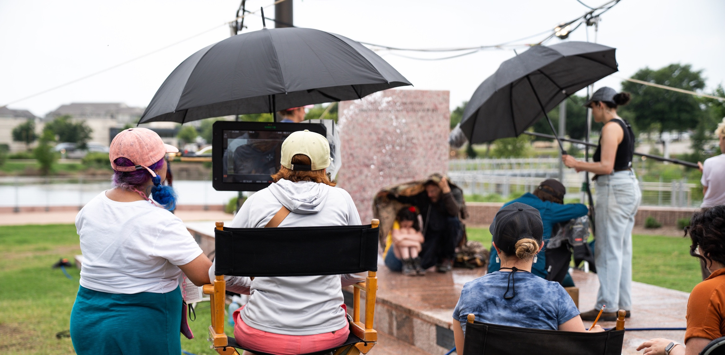 Behind directors chairs of film crew on site during outdoor filming