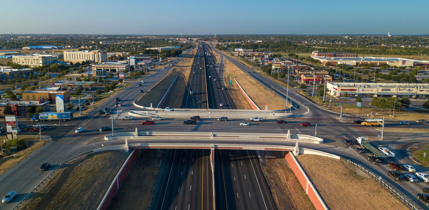 Drone shot of highway intersection showcasing the city