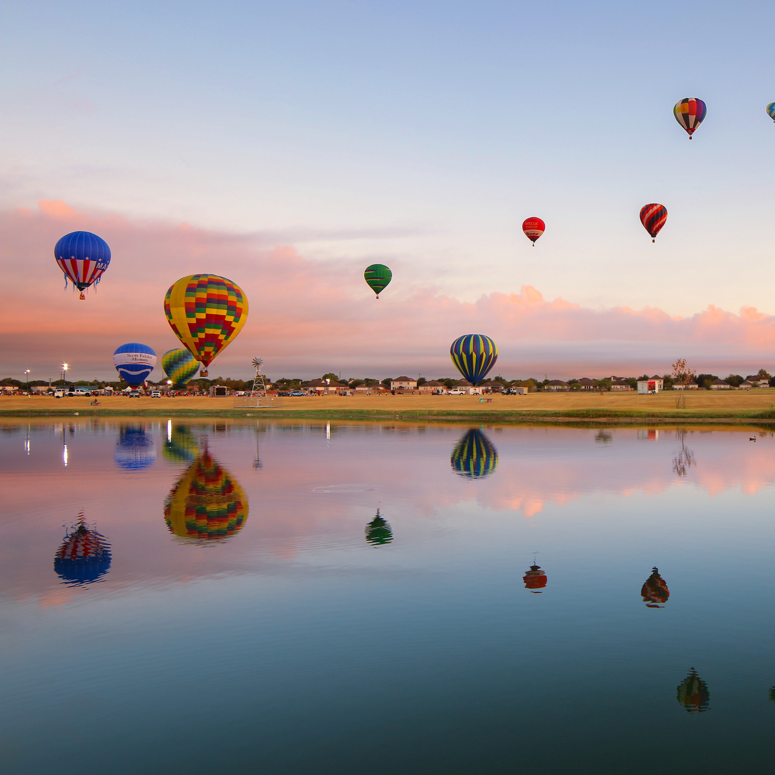 Hot air balloons over a pond